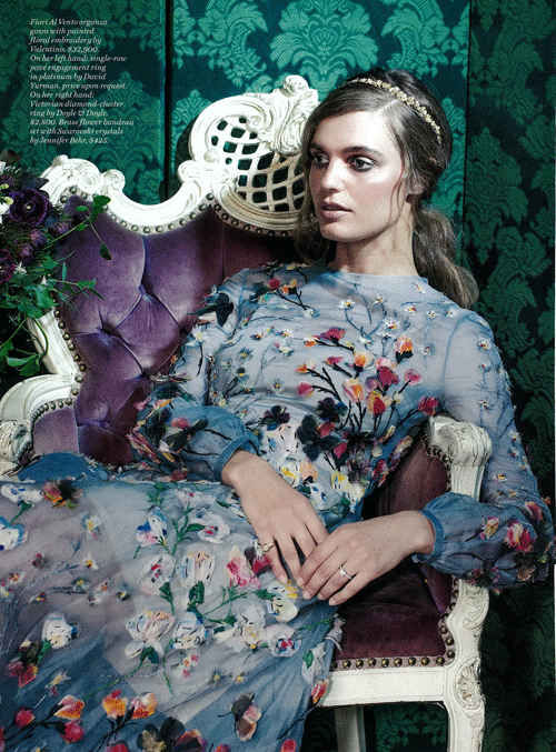 This image features a model wearing the Fiori Al Vento organza gown by Valentino, a piece characterized by its light blue silk organza and intricate painted floral embroidery.