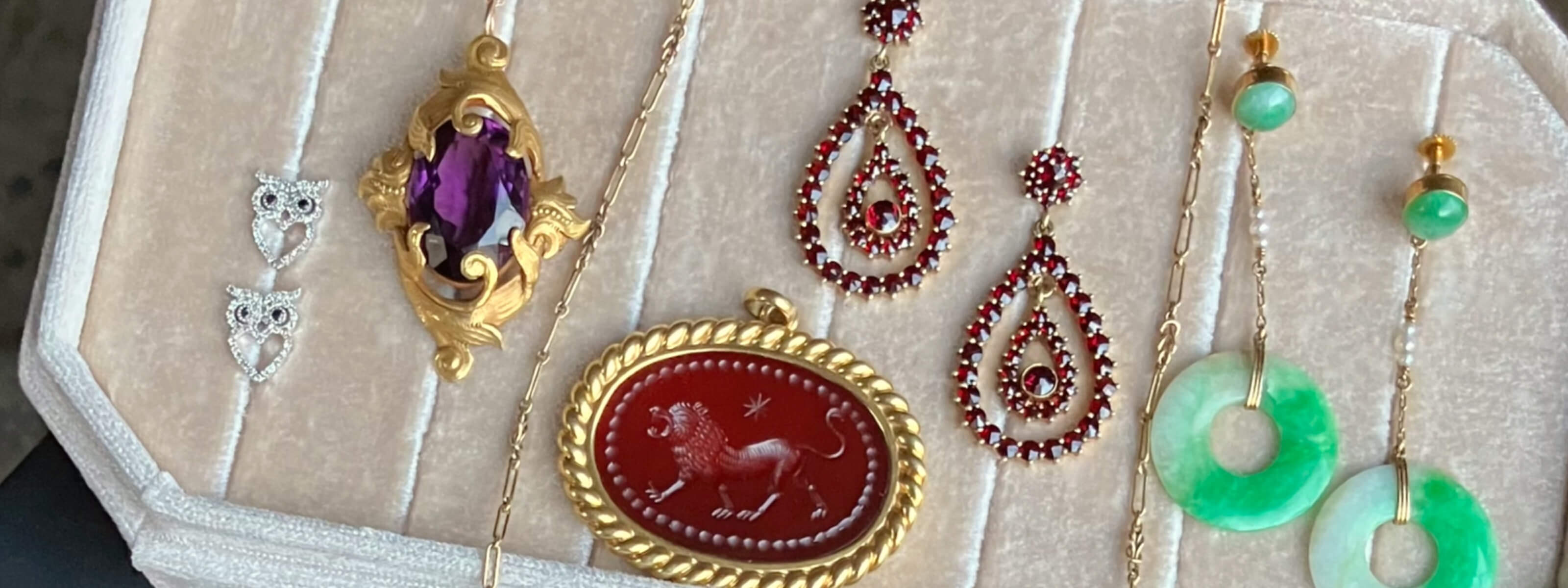 Vintage and Antique jewelry displayed on beige fabric