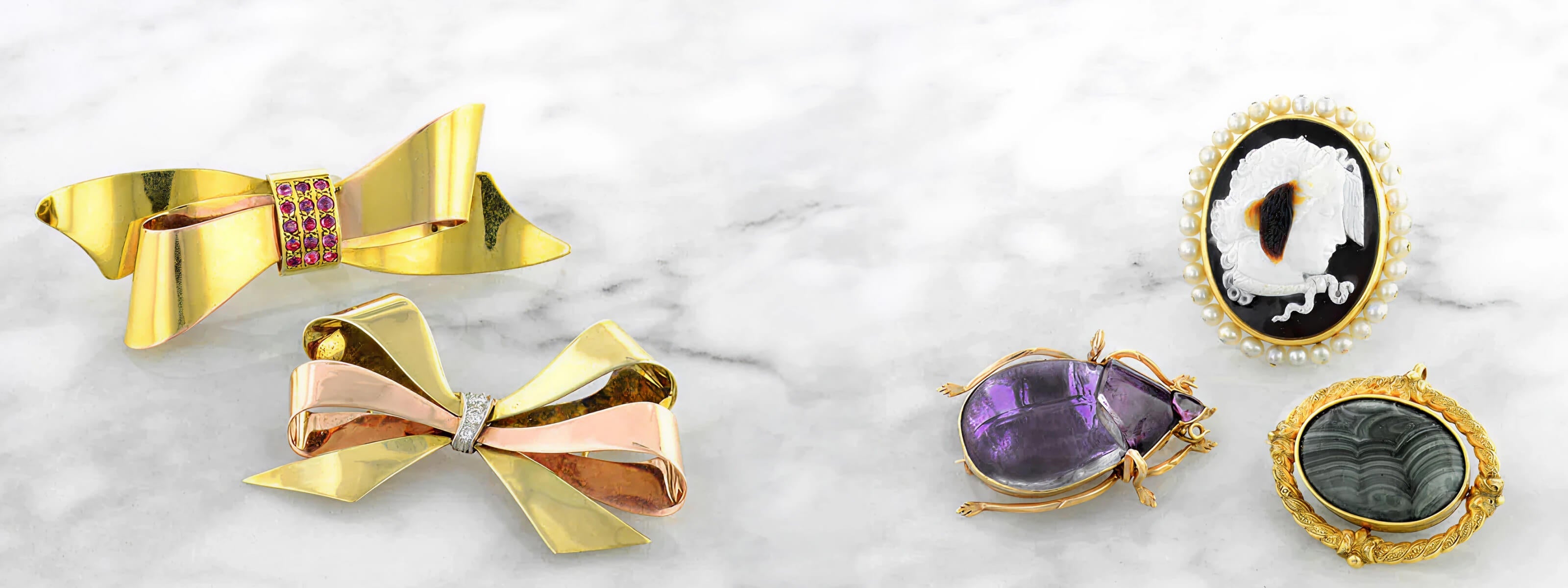 variety of antique brooches on a marble surface