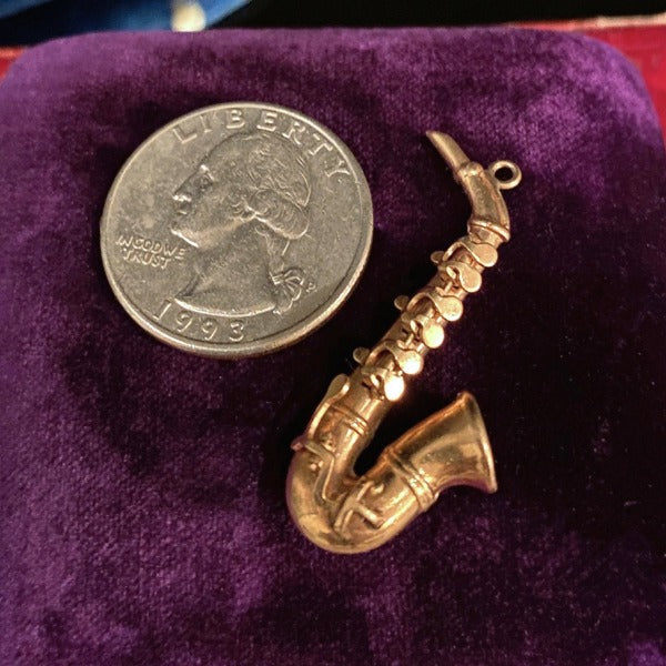 Antique mechanical saxophone gold charm pendant, from Doyle & Doyle jewelry boutique.