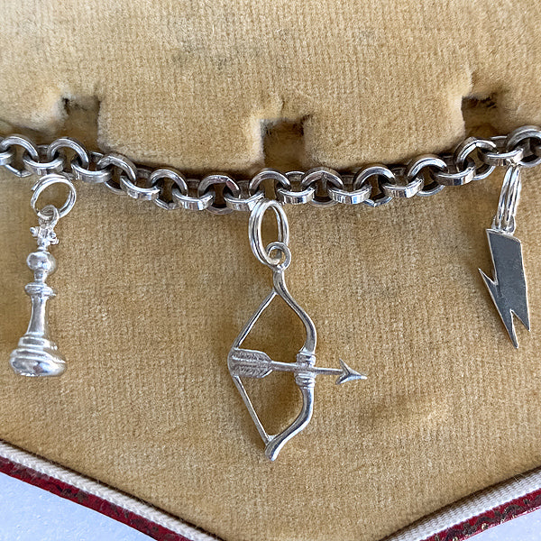 Chess Queen charm, Bow & Arrow charm, and Lightning Bolt charm in sterling silver, Heirloom by Doyle & Doyle collection. From Doyle & Doyle jewelry.